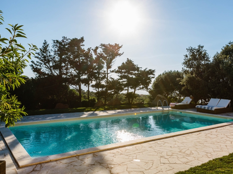 Sonniger Blick auf den Pool und die Liegestühle im Borgo Lu Puleu